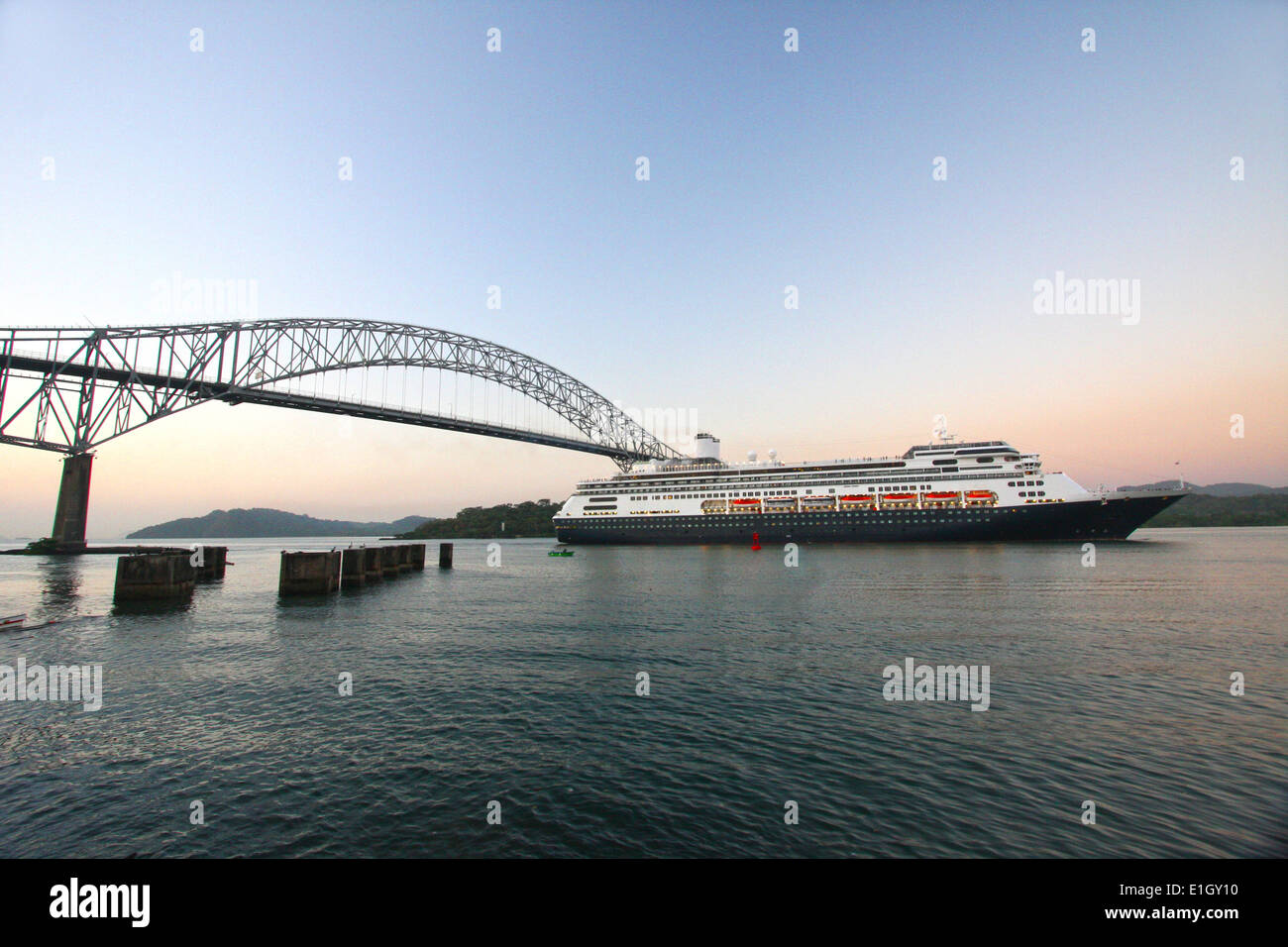 Cruise ship sailing under the Bridge of the Americas at sunrise. The ship is entering the Panama Canal on the Pacific side. Stock Photo