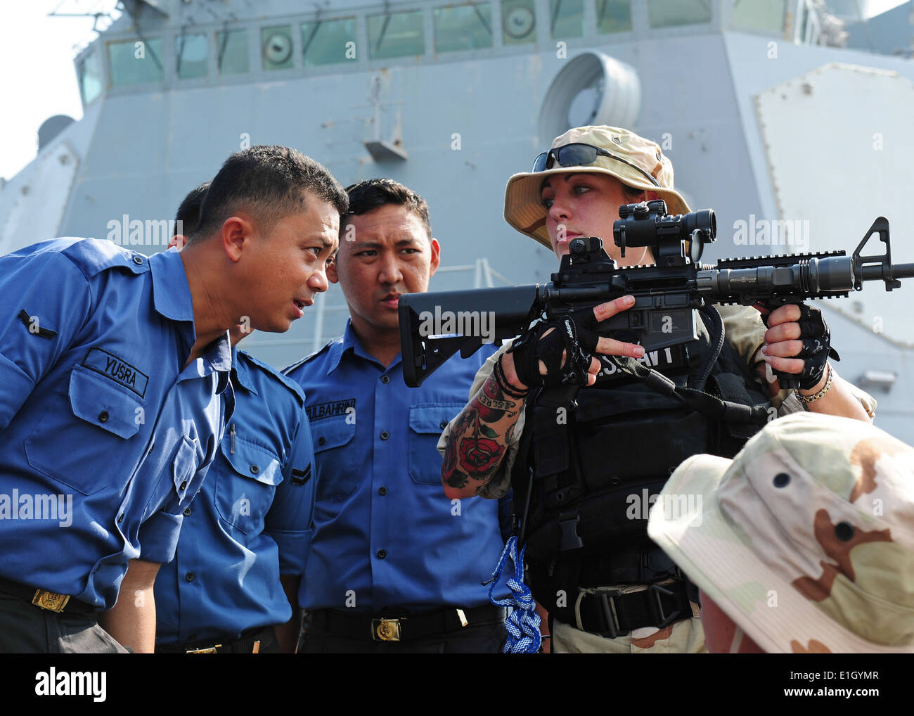 U.S. Navy Fire Controlman 2nd Class Christi Hoopes asks a Royal Brunei Navy boarding team member to look through the sight of h Stock Photo