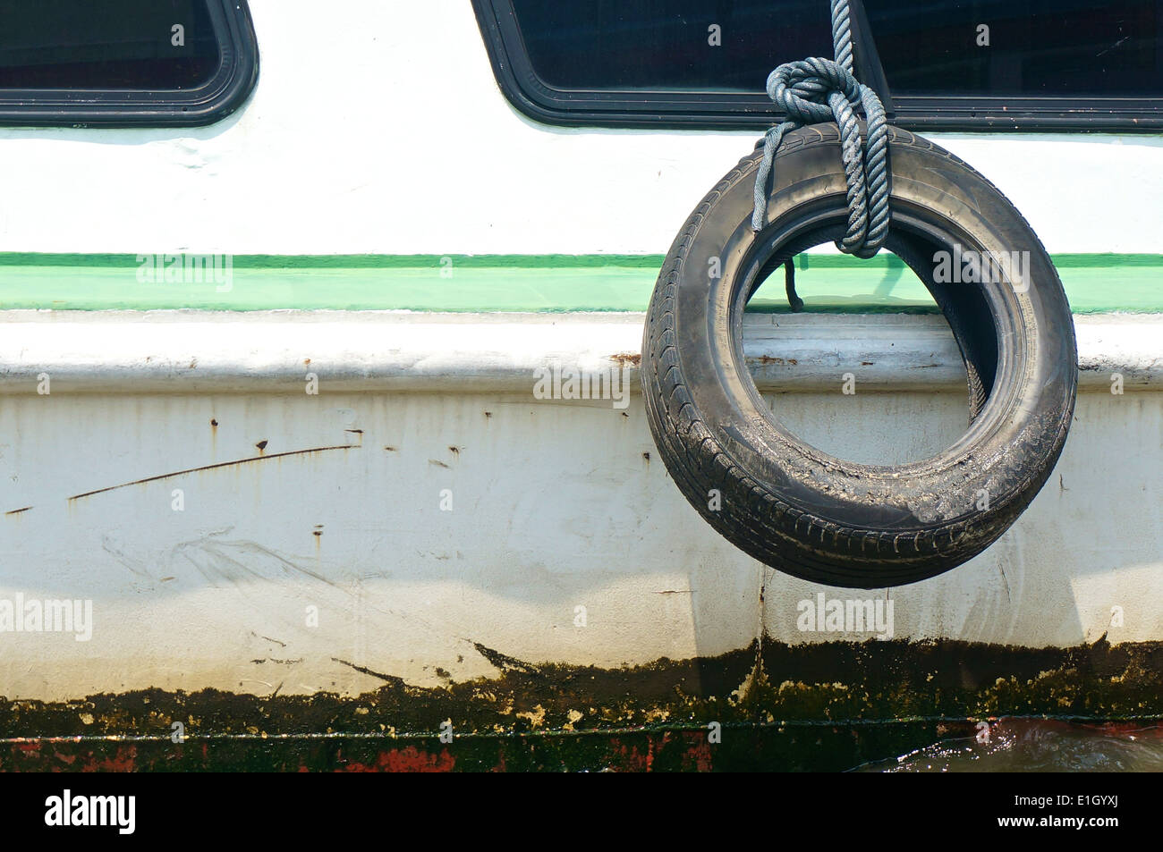 Old used tire with rope on the side of boat for fender Stock Photo Alamy
