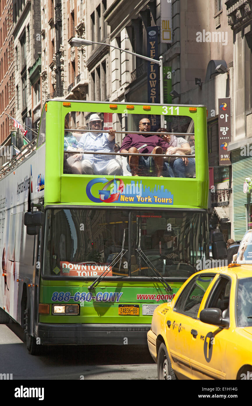 Tour bus in midtown Manhattan. You get a good view from the upper deck. Stock Photo