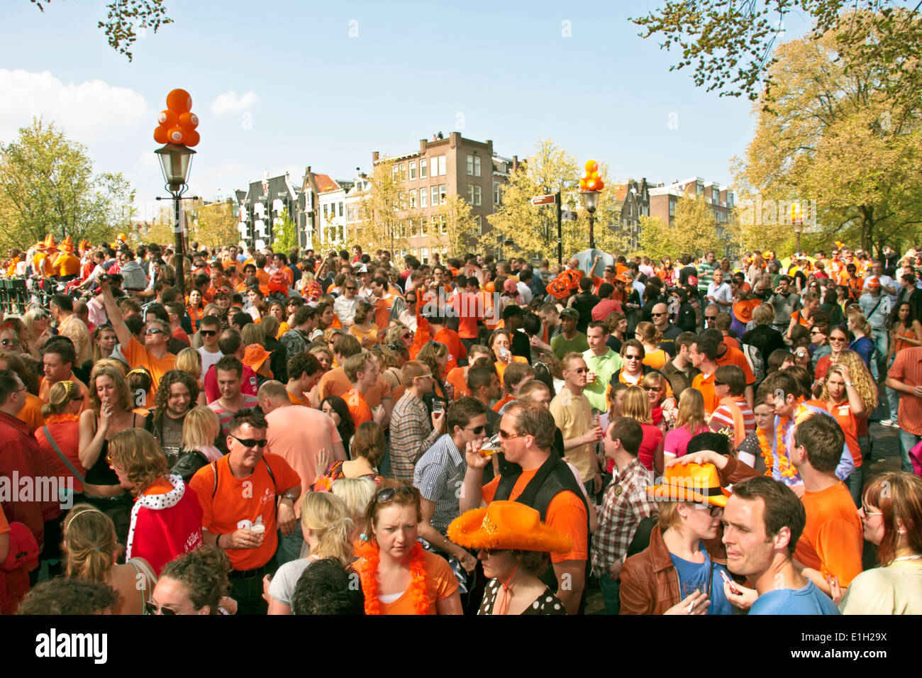 Big orange crowd of people partying in the streets from Amsterdam on kings day in the Netherlands Stock Photo