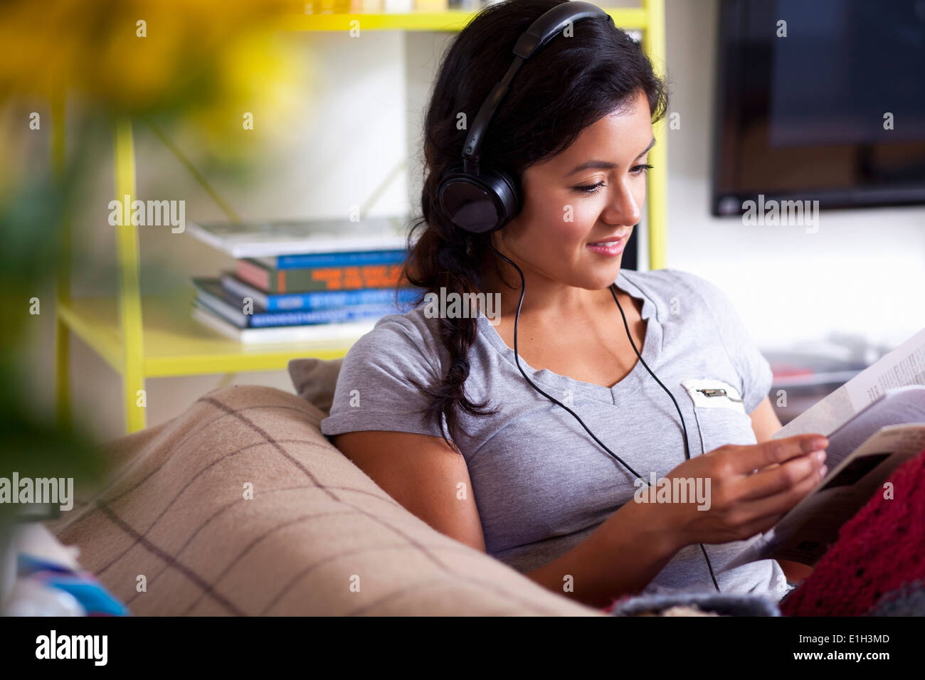 Young woman reading and listening to music Stock Photo