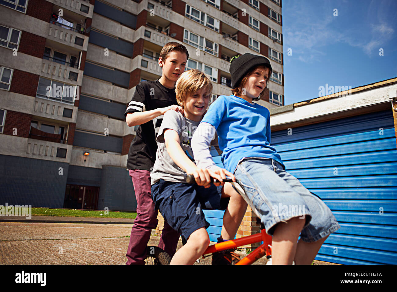 Boy giving two friends a ride on bike Stock Photo