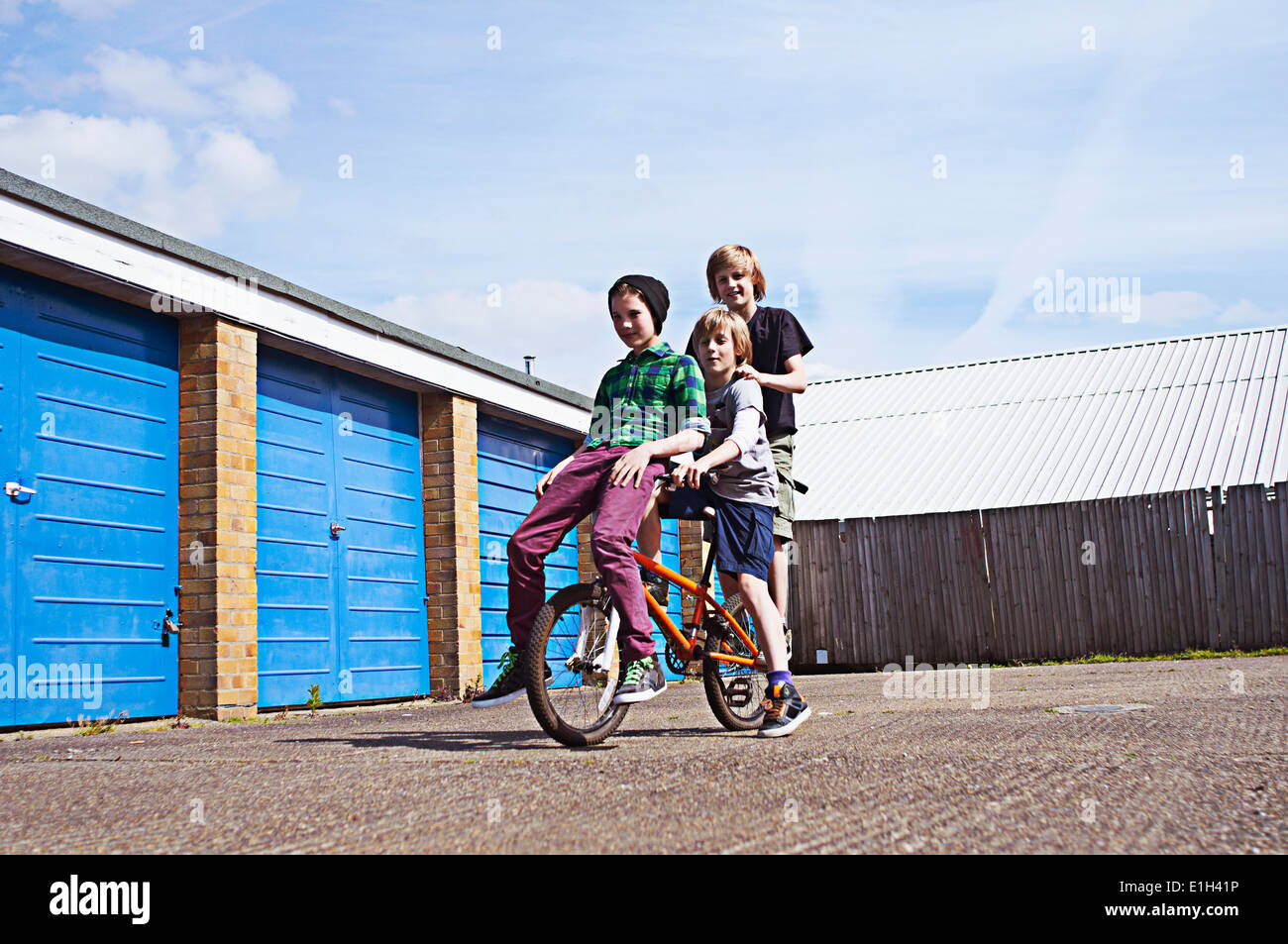 Boy giving friends a ride on bike Stock Photo