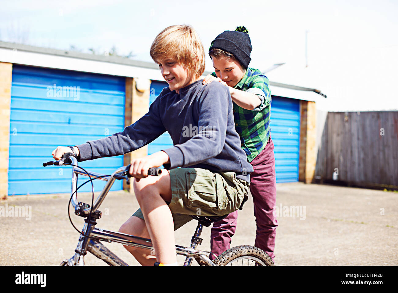 Boy giving friend a ride on back of bike Stock Photo