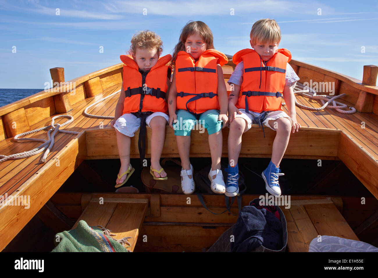 Three children sitting in boat Stock Photo