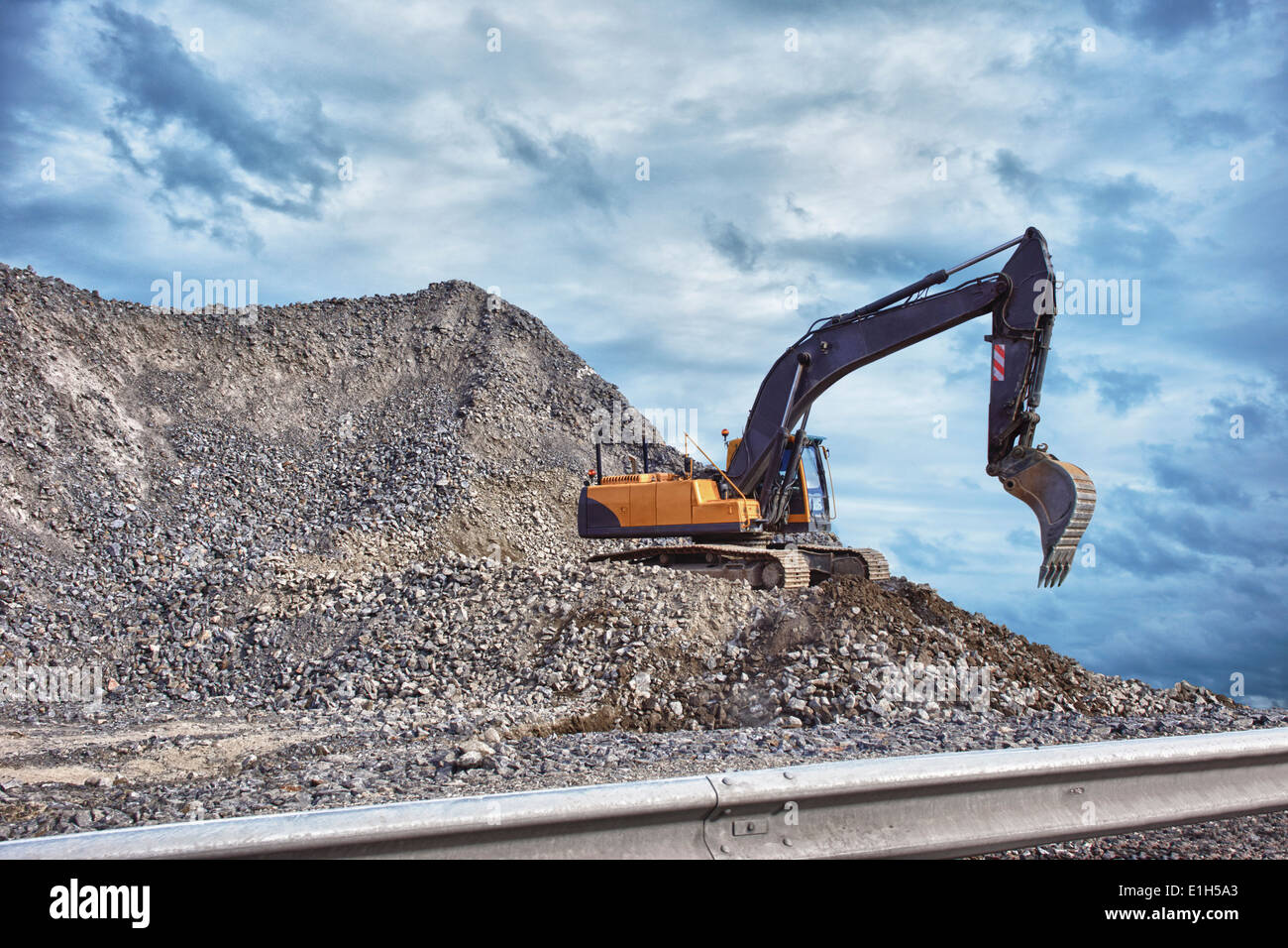 Excavator and mound of construction material Stock Photo