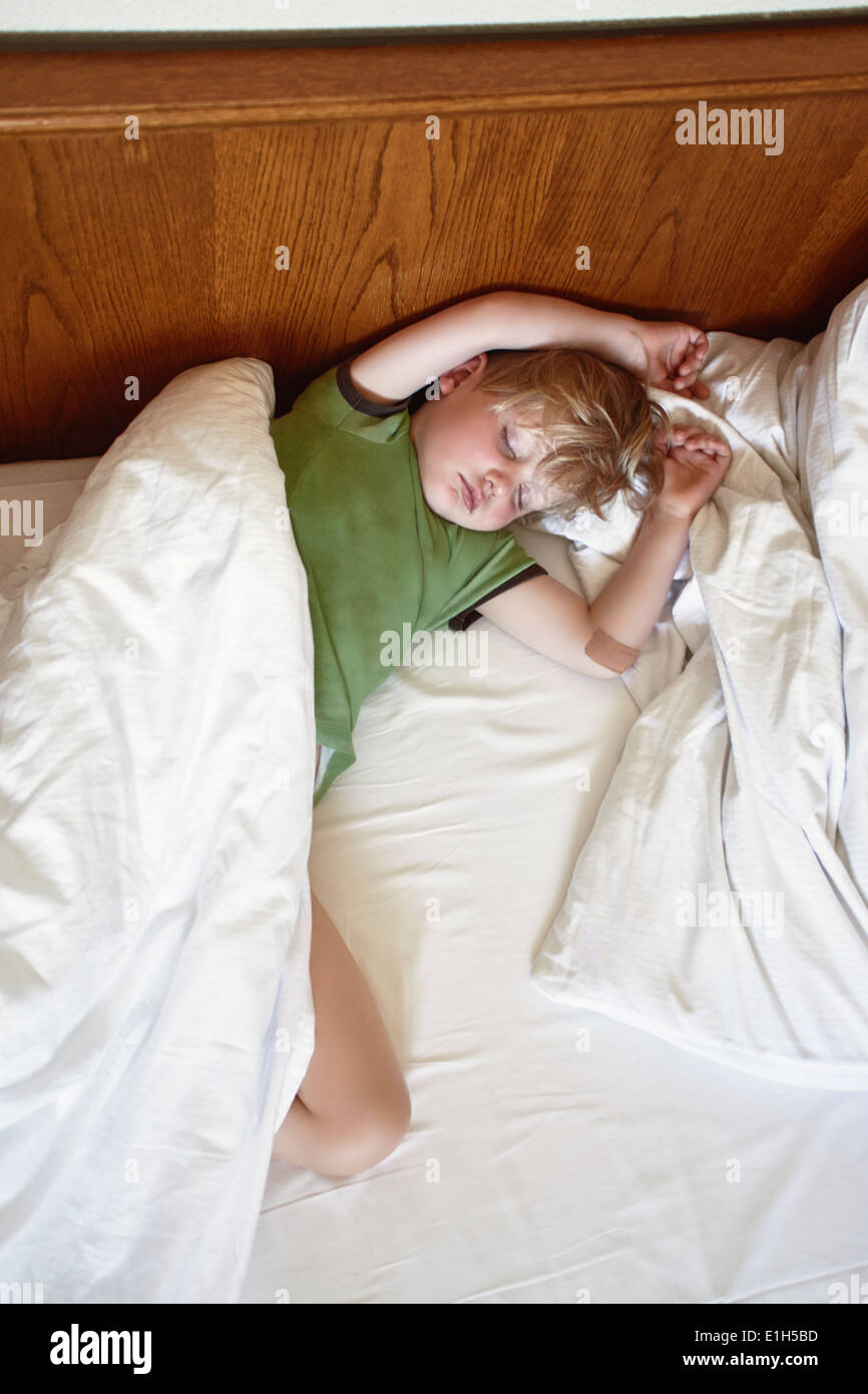 Young boy sleeping on bed Stock Photo