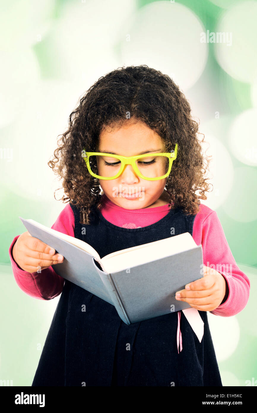 Little girl holding and reading book Stock Photo - Alamy