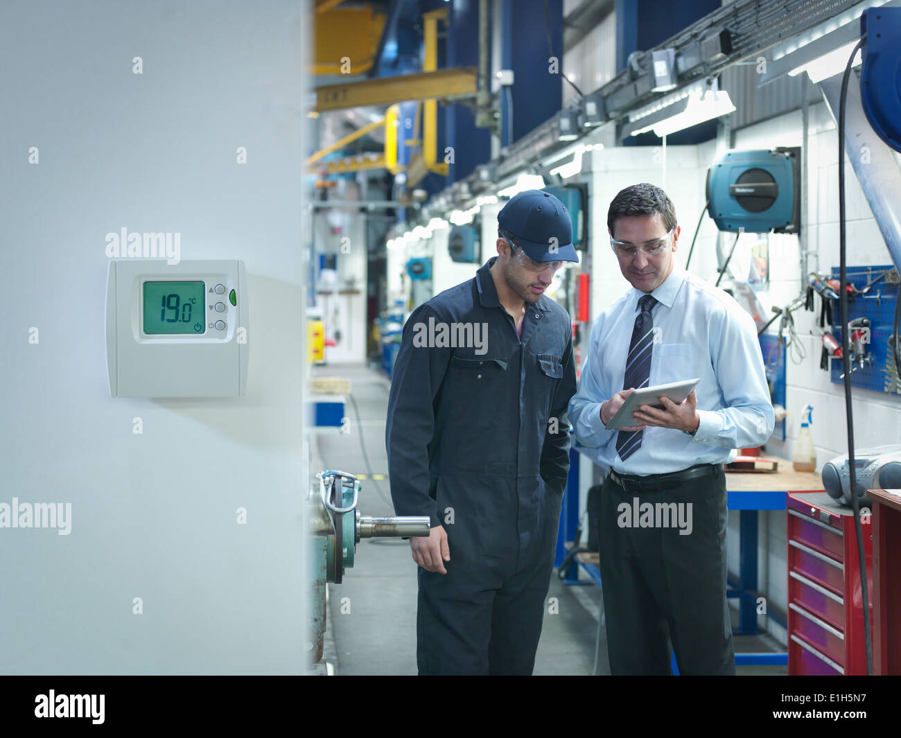 Factory and office worker discussing energy saving in factory Stock Photo