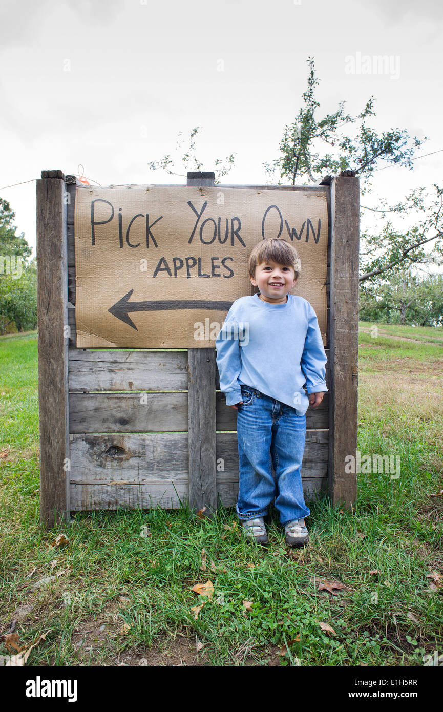 Portrait of cute boy in front of pick your own sign Stock Photo