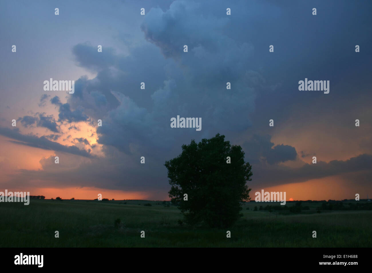 A low precipitation supercell peeks out above the setting sun on the horizon, Garden City, Kansas, USA Stock Photo