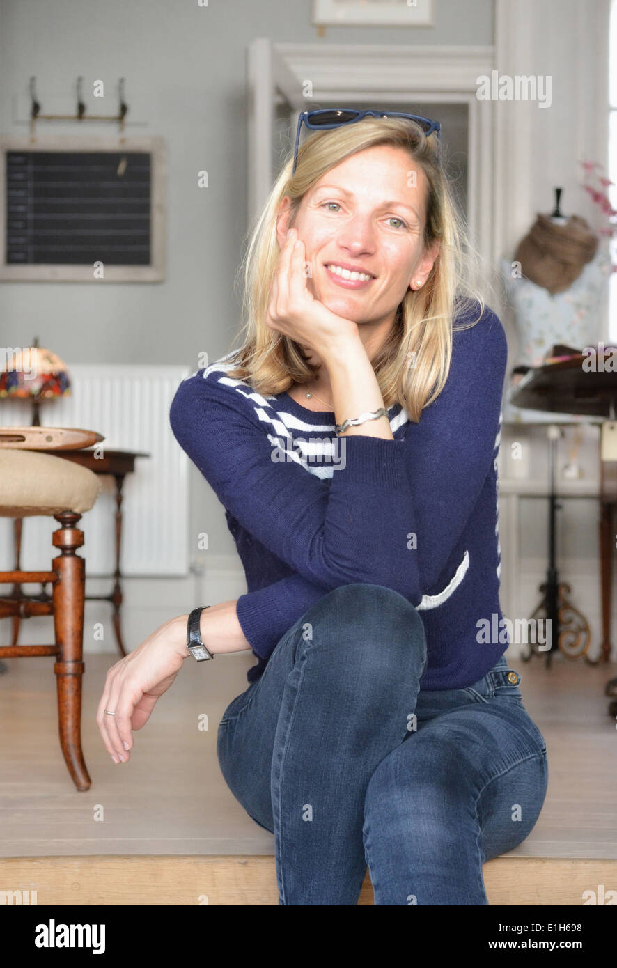 Portrait of mature female shop keeper sitting on step Stock Photo
