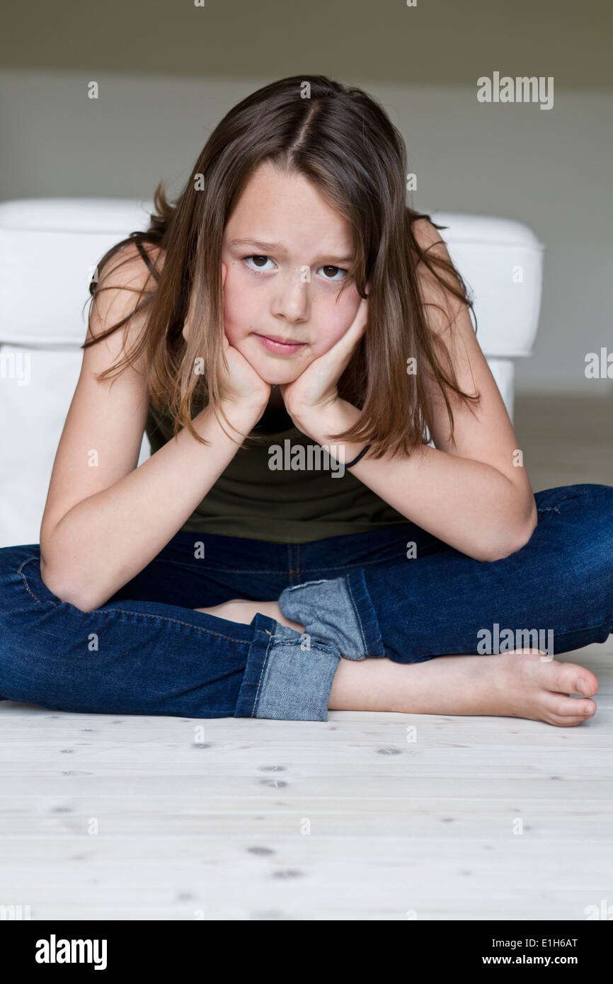 Portrait of unhappy twelve year old girl with head in hands Stock Photo