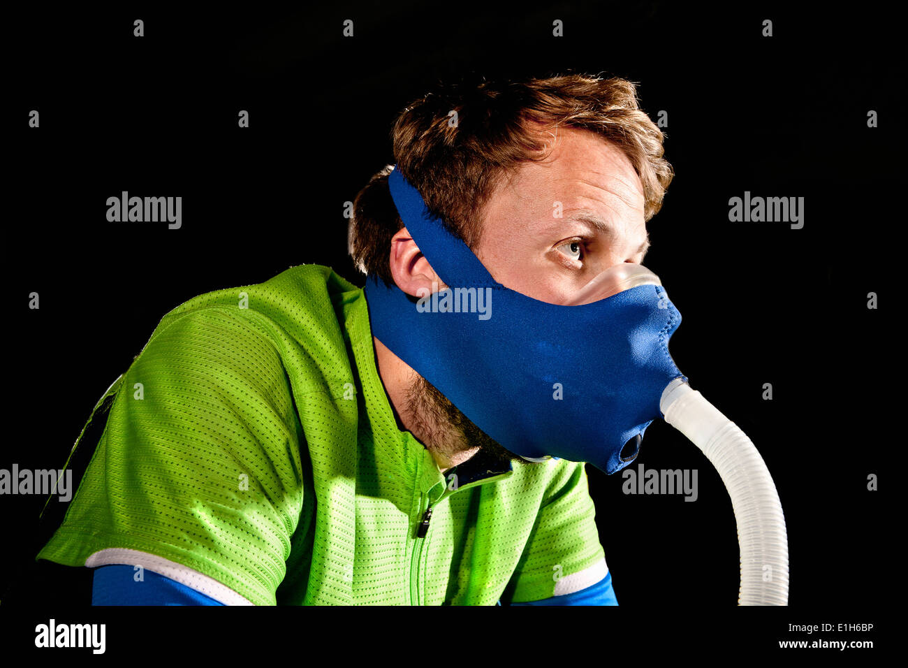 Close up of young man in face mask on gym exercise cycle in altitude centre Stock Photo