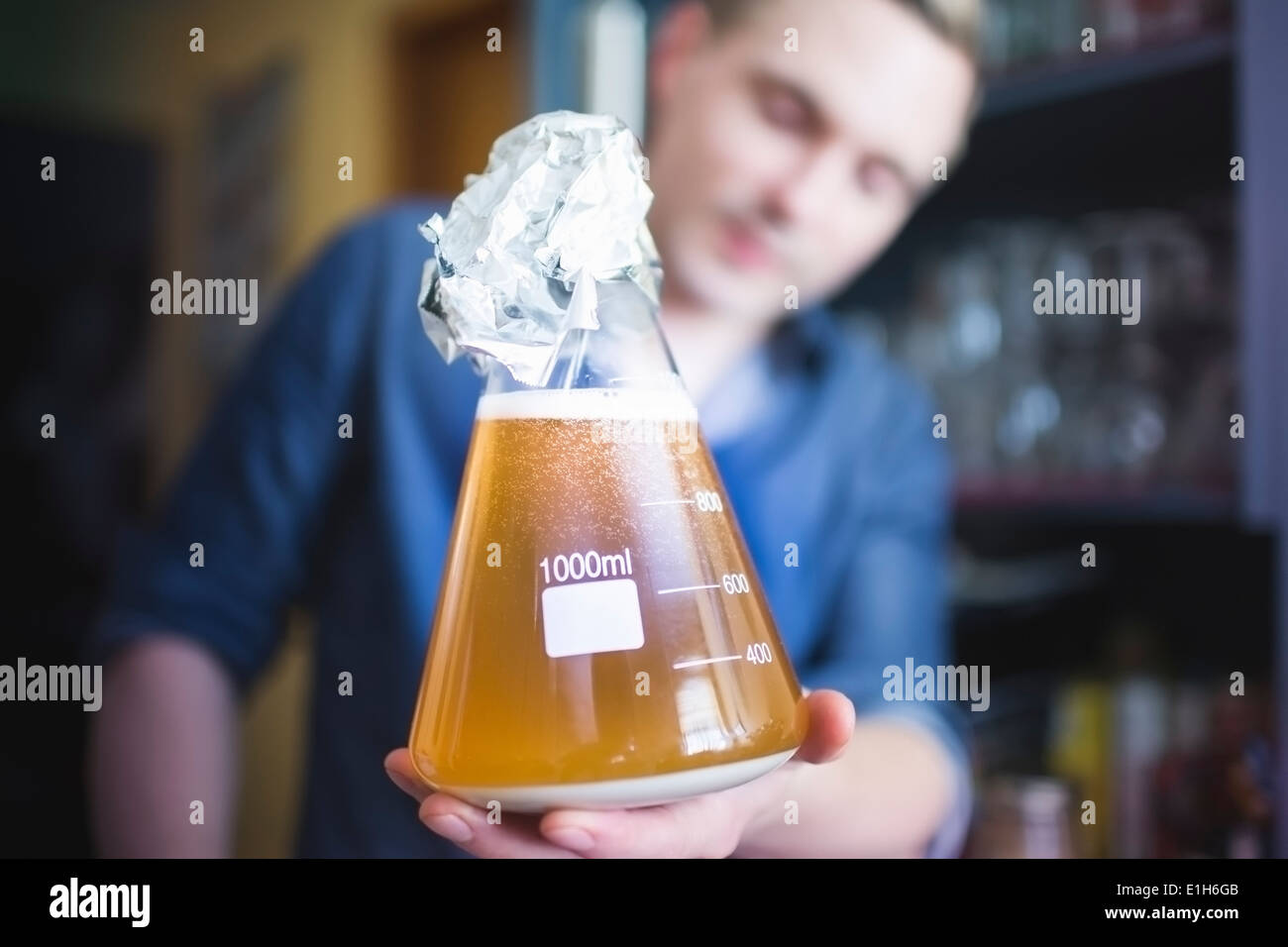 Mid adult man with flask of yeast for home brew beer Stock Photo
