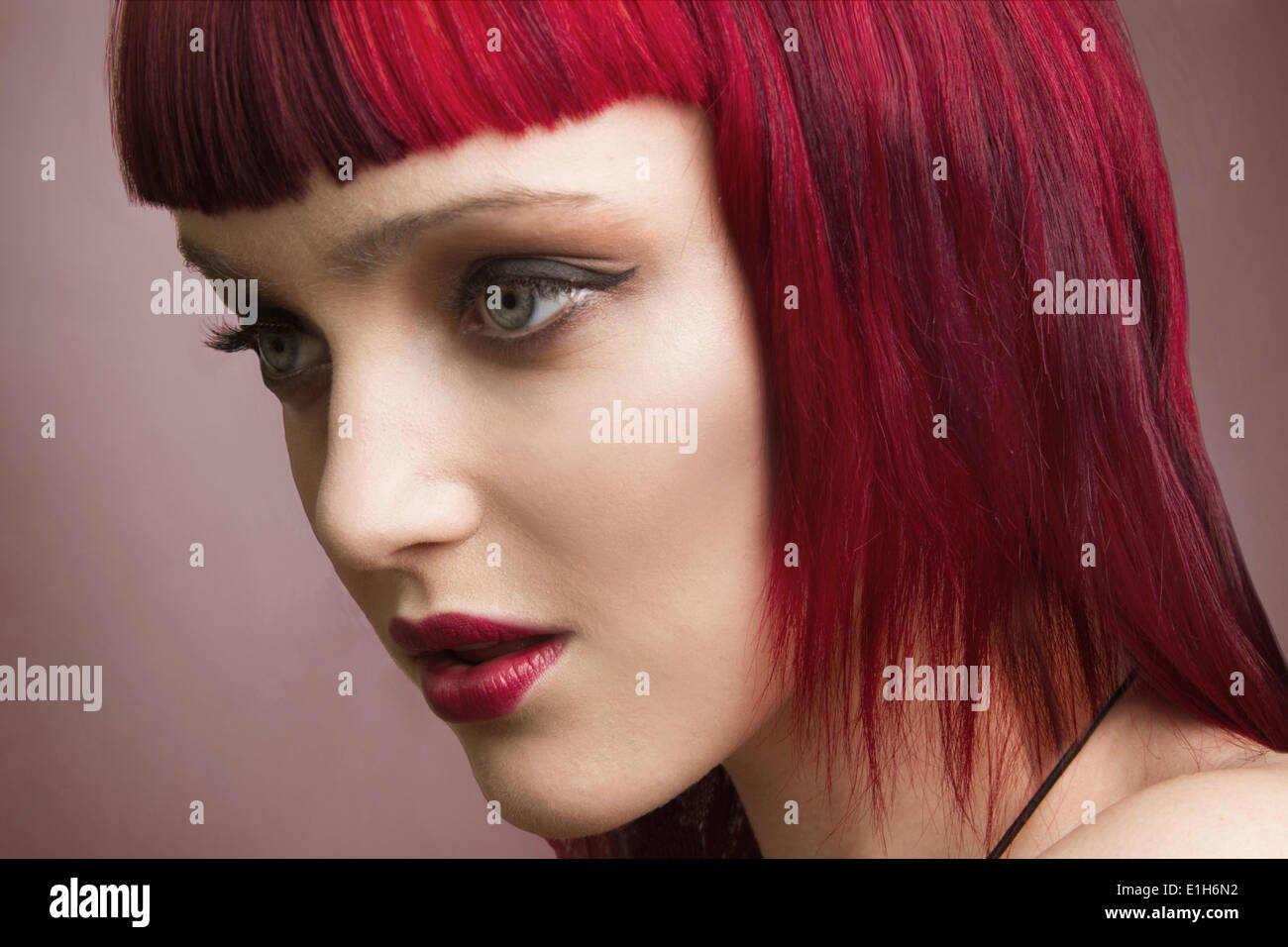 Close up studio portrait of young woman with pink hair Stock Photo