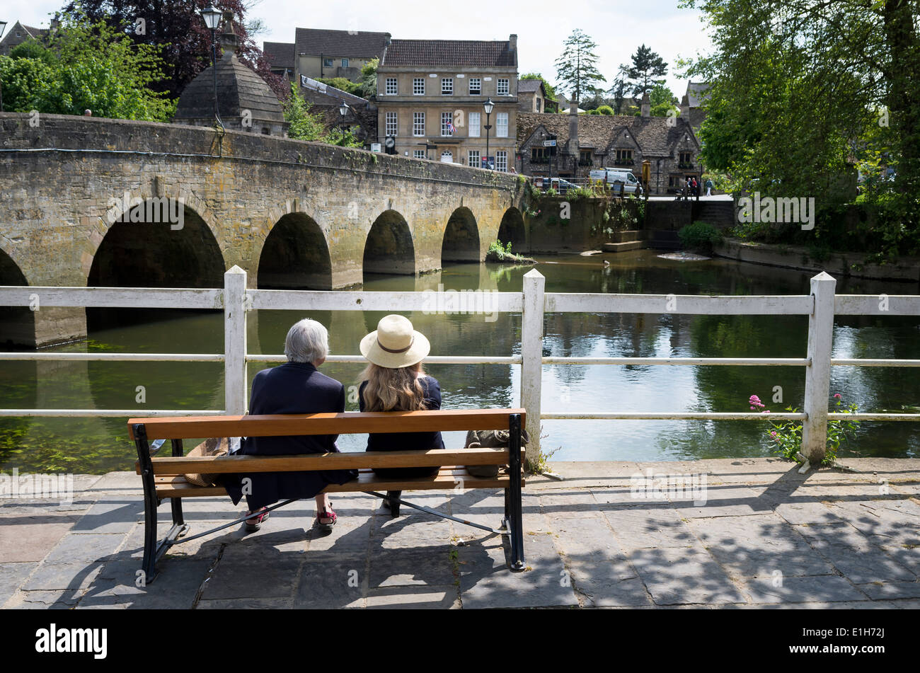Two ladies resting on a seat beside the River Avon in Bradford on Avon UK Stock Photo