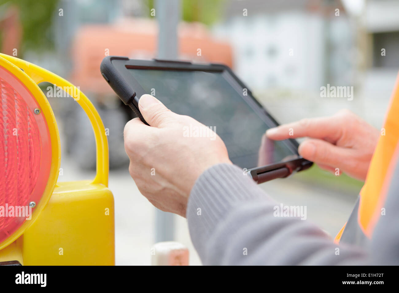 Foremans hands using digital tablet on road construction site Stock Photo