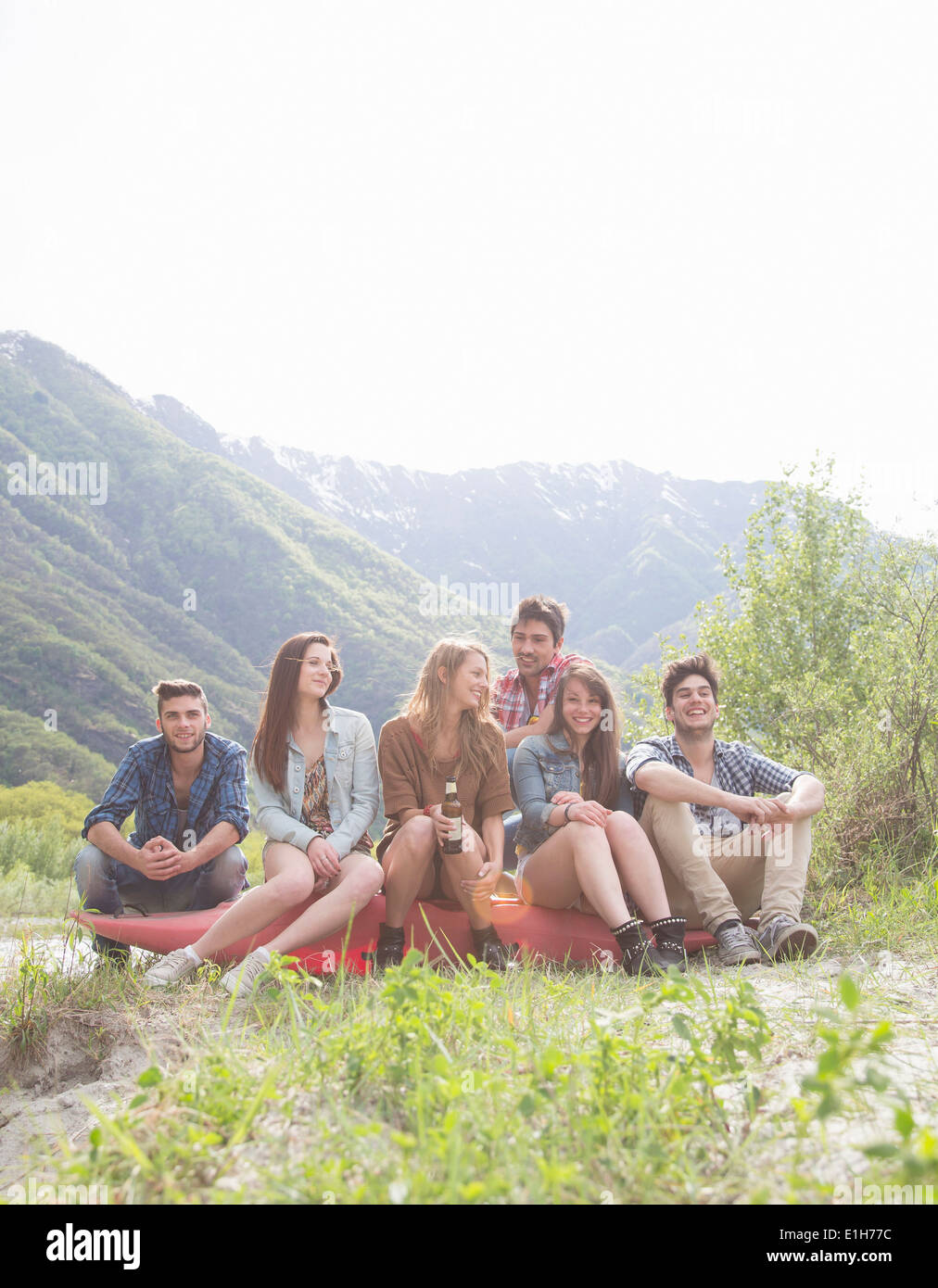 Group of six young adult friends sitting on canoe, Piemonte, Italy Stock Photo