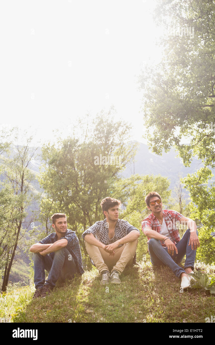 Three young men sitting on grass Stock Photo