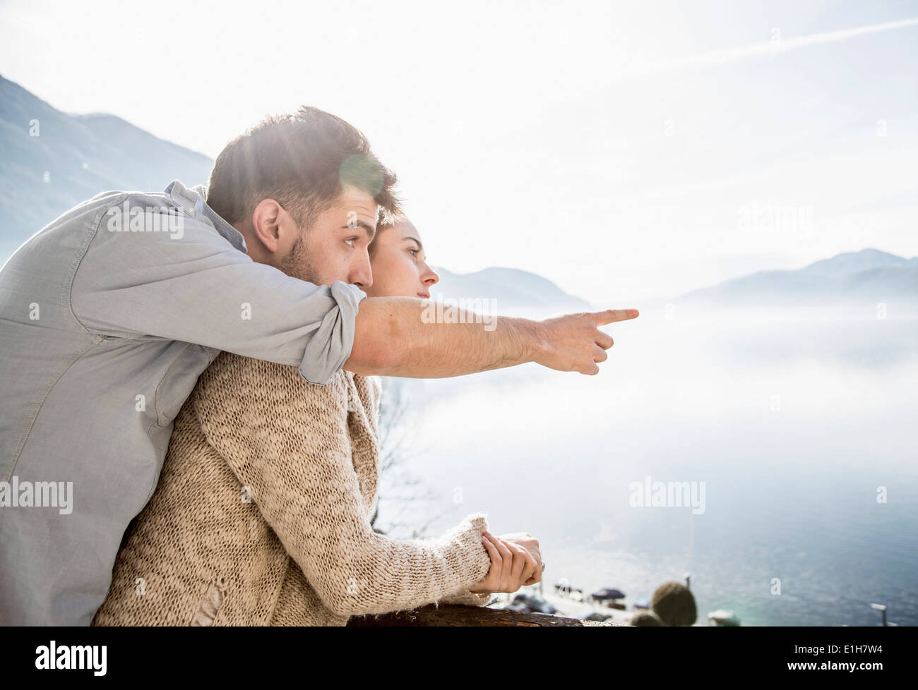 Young couple looking at view of lake and mountains Stock Photo