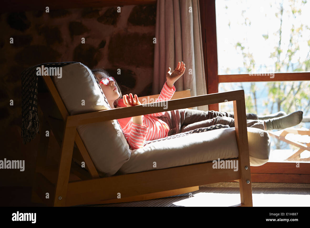 Young girl sitting on rocking chair daydreaming Stock Photo