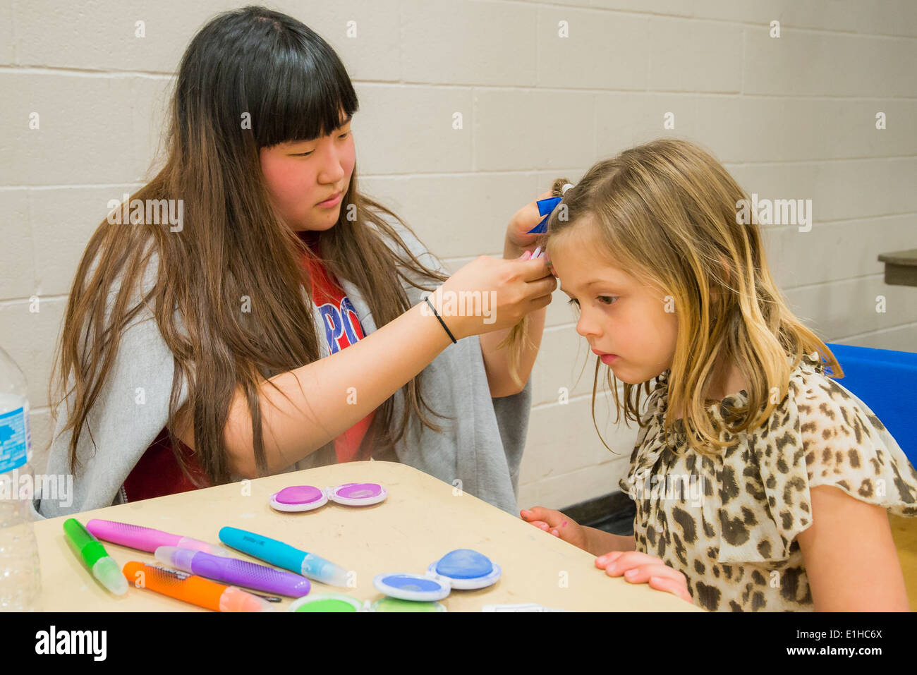 Young girl gets temporary hair chalk applied at Spring Fair Stock Photo