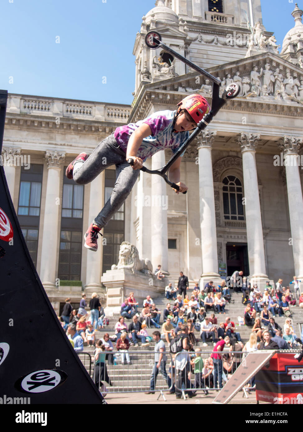 A scooter rider performs an aerial stunt in front of the Portsmouth Guildhall during the Portsmouth street games 2014 Stock Photo