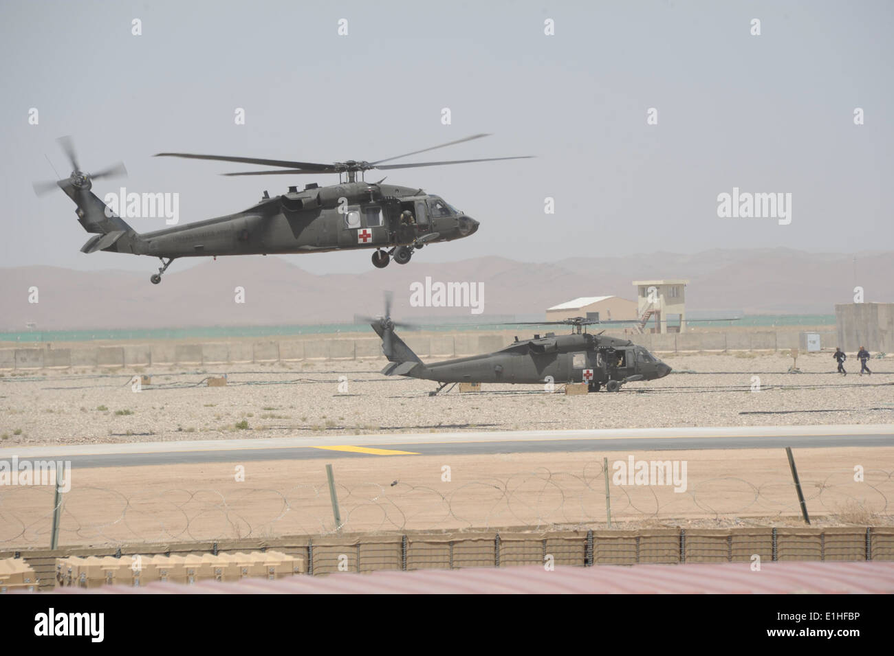 Two U.S. Army UH-60 Black Hawk medical evacuation helicopters with Task Force Storm, 12th Combat Aviation Brigade land at the r Stock Photo