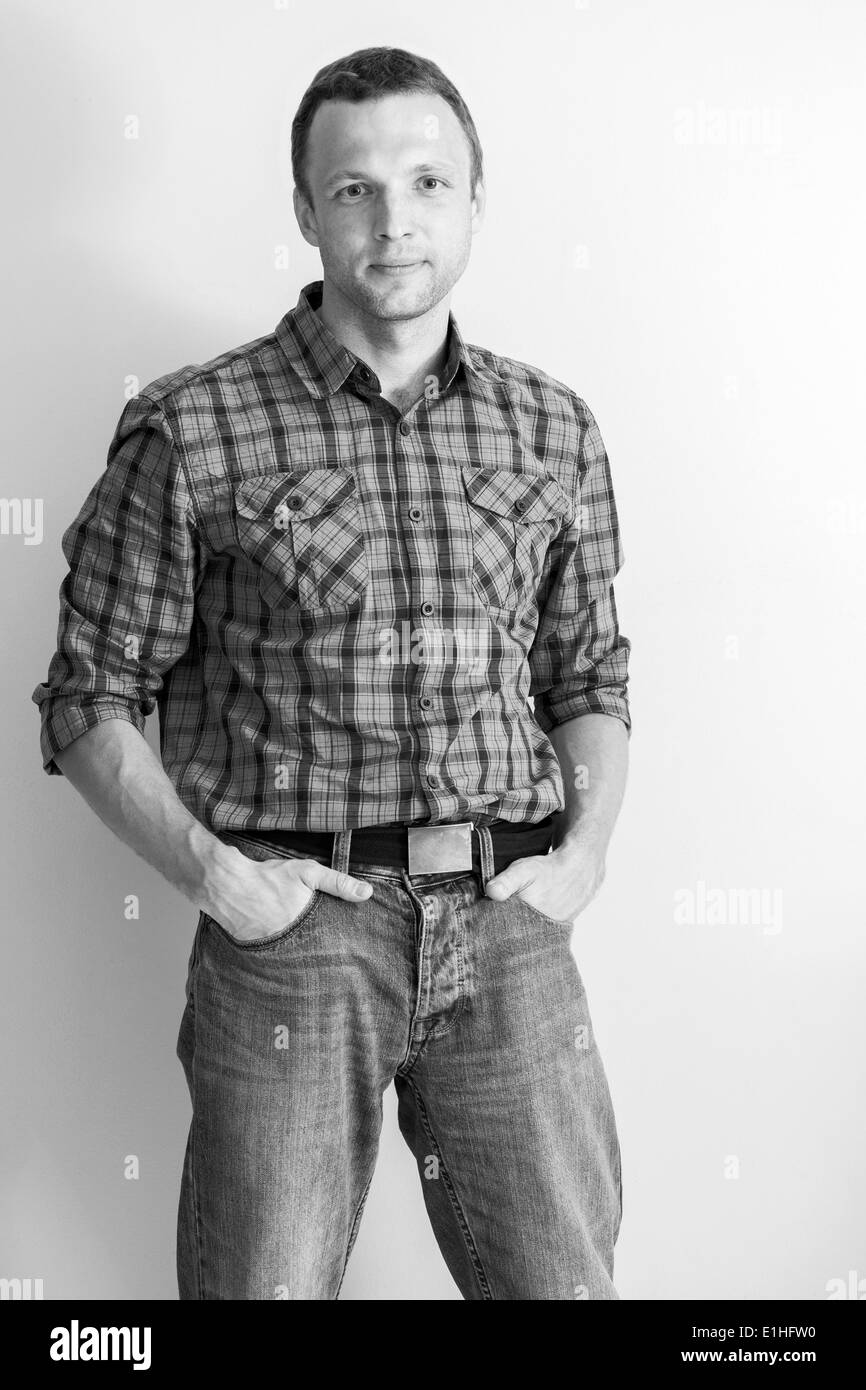 Young Caucasian man in checkered shirt and jeans. Black and white portrait Stock Photo