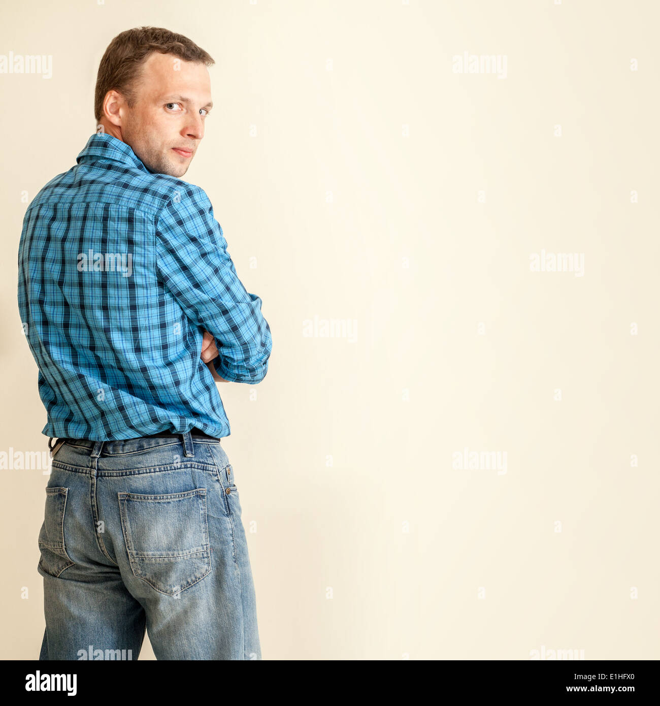Young Caucasian man in blue shirt and jeans, studio portrait Stock Photo