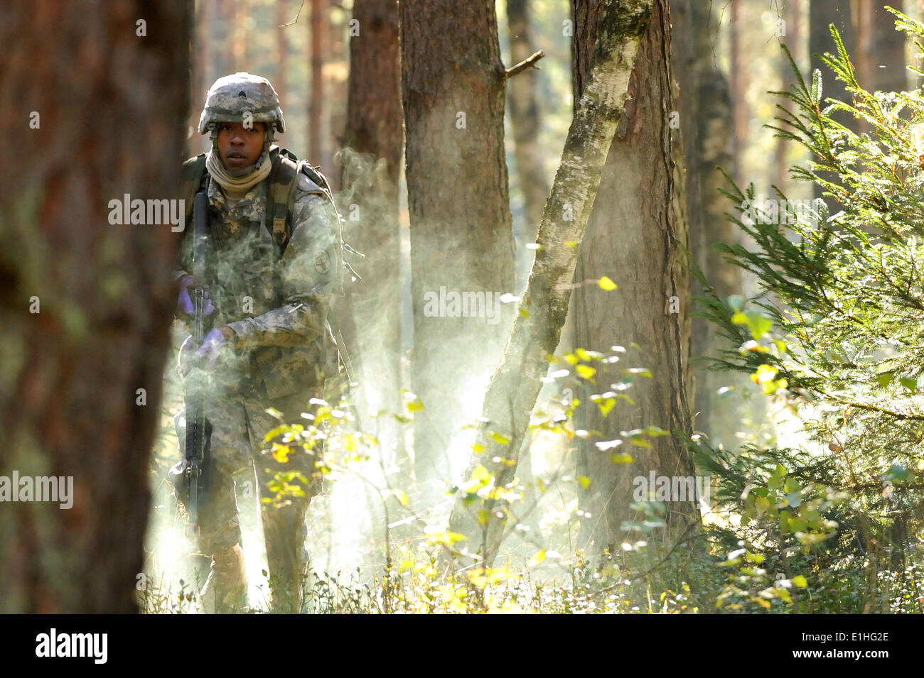 U.S. Army Sgt. Brandon Jemison, assigned to Europe Regional Medical Command, runs through a smoke-filled testing lane during th Stock Photo