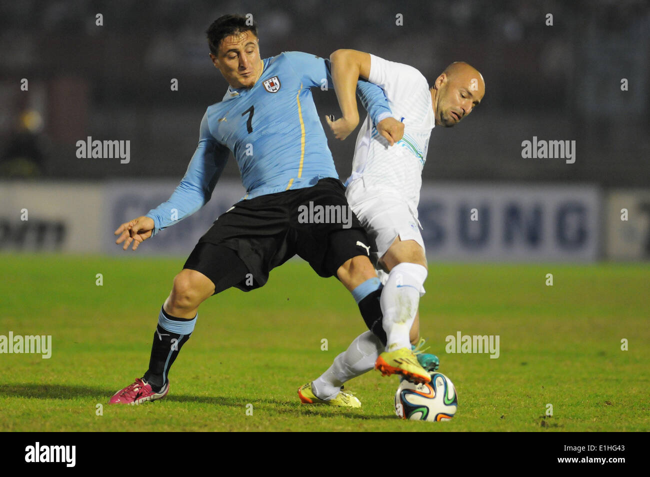 Montevideo, Uruguay. 4th June, 2014. Uruguay's Cristian Rodriguez (L) vies for the ball with Slovenia's Miso Brecko during a friendly match prior to the 2014 FIFA World Cup, held at the Centenario Stadium, in Montevideo, capital of Uruguay, on June 4, 2014. © Nicolas Celaya/Xinhua/Alamy Live News Stock Photo