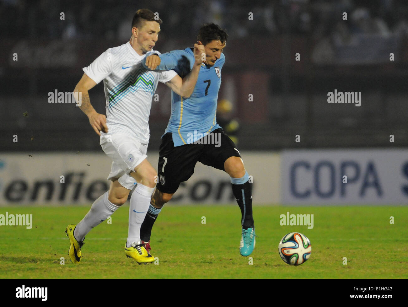 Montevideo, Uruguay. 4th June, 2014. Uruguay's Cristian Rodriguez vies for the ball with Slovenia's Rajko Rotman (L) during a friendly match prior to the 2014 FIFA World Cup, held at the Centenario Stadium, in Montevideo, capital of Uruguay, on June 4, 2014. © Nicolas Celaya/Xinhua/Alamy Live News Stock Photo