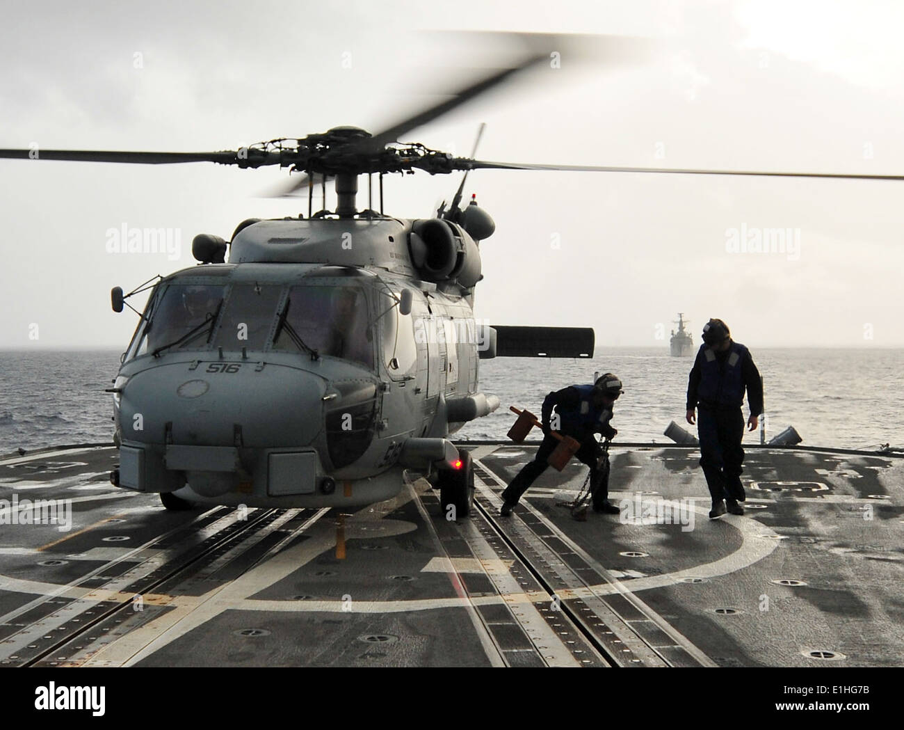 U.S. Sailors remove chocks and chains from an SH-60B Seahawk helicopter assigned to Helicopter Anti-Submarine Squadron Light (H Stock Photo