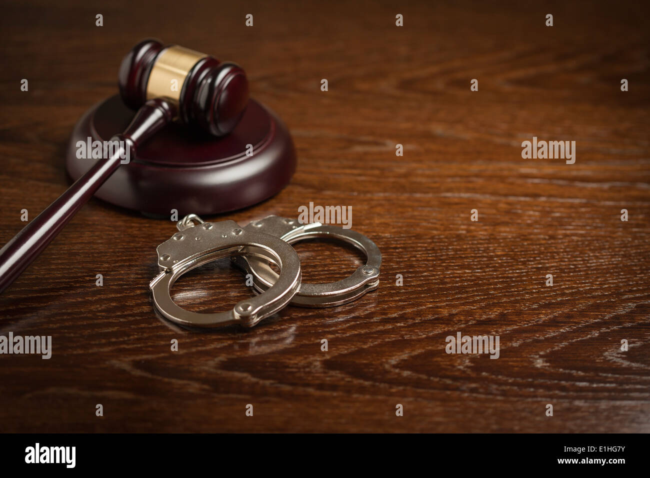 Gavel and Pair of Handcuffs on Wooden Table. Stock Photo