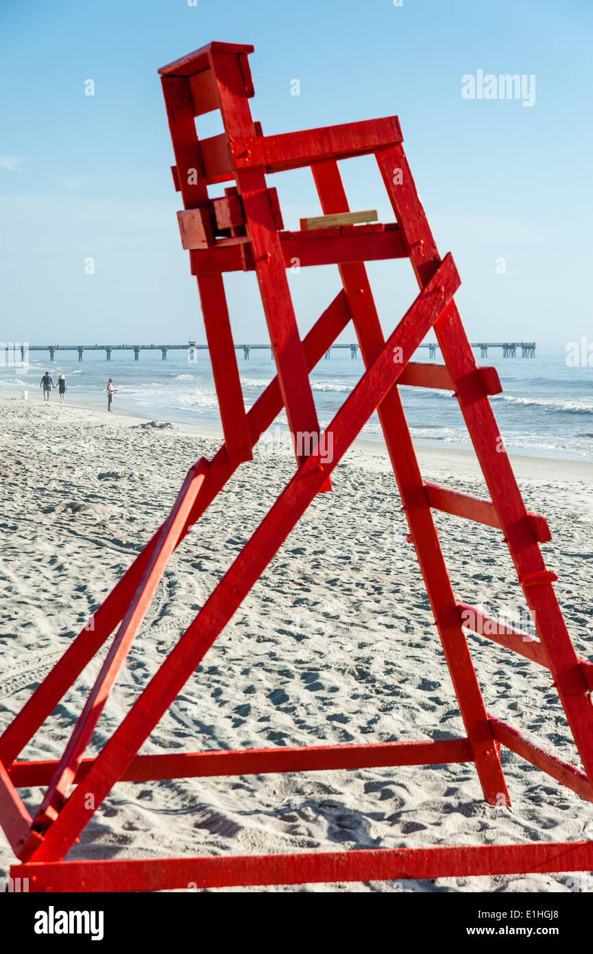 Early morning risers fish, stroll and surf beyond the empty lifeguard stand at Jacksonville Beach, Florida, USA. Stock Photo
