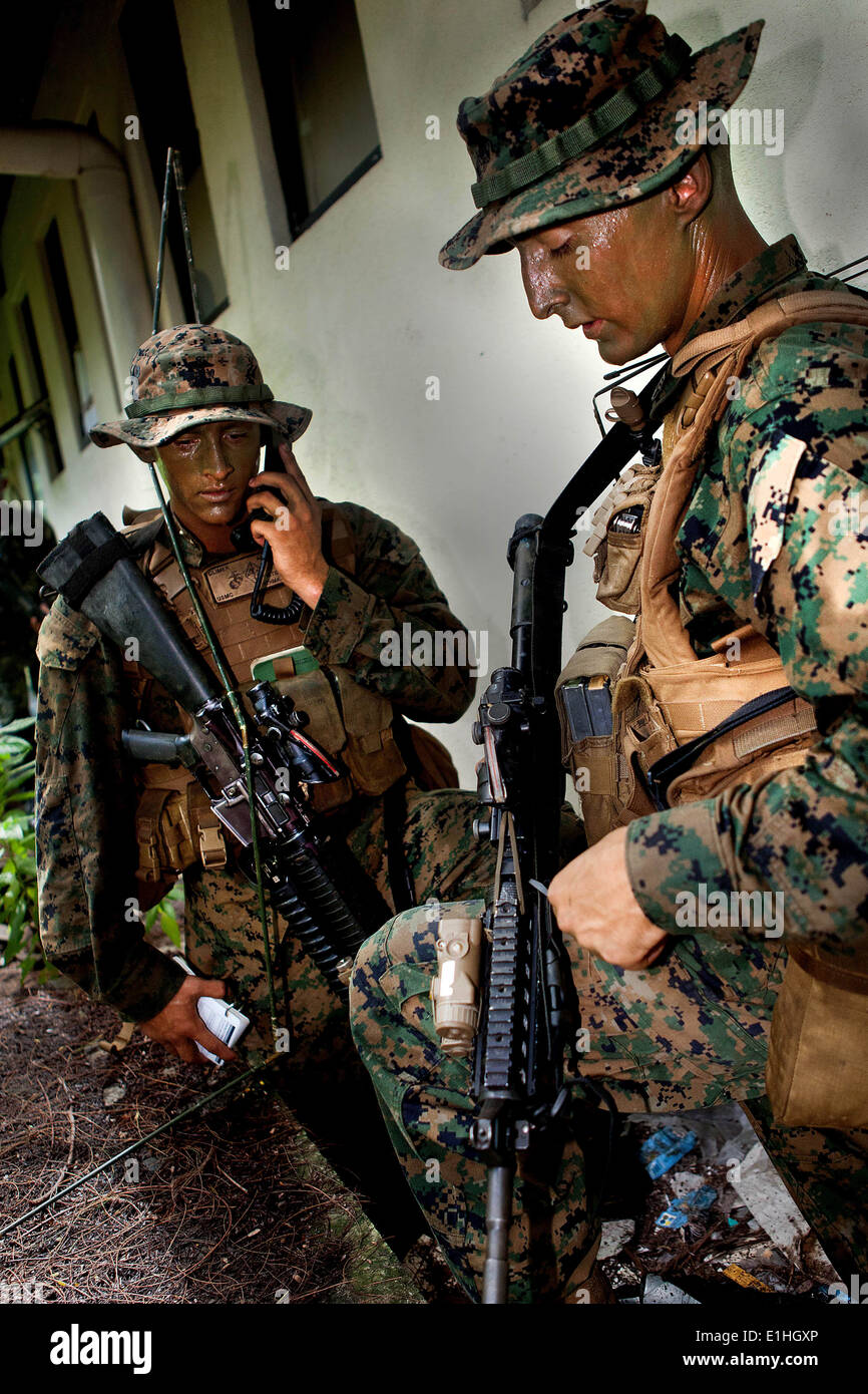 U.S. Marine Corps Lance Cpl. Clayton Climer, left, a rifleman, calls in a medical evacuation request as Staff Sgt. Jeremy Ludwi Stock Photo