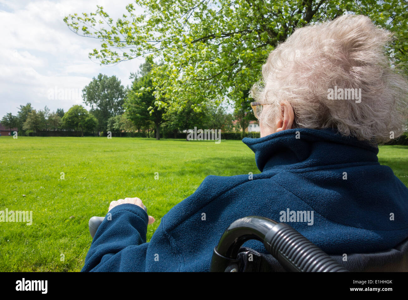 Elderly lady in her enjoying fresh air in public park. UK