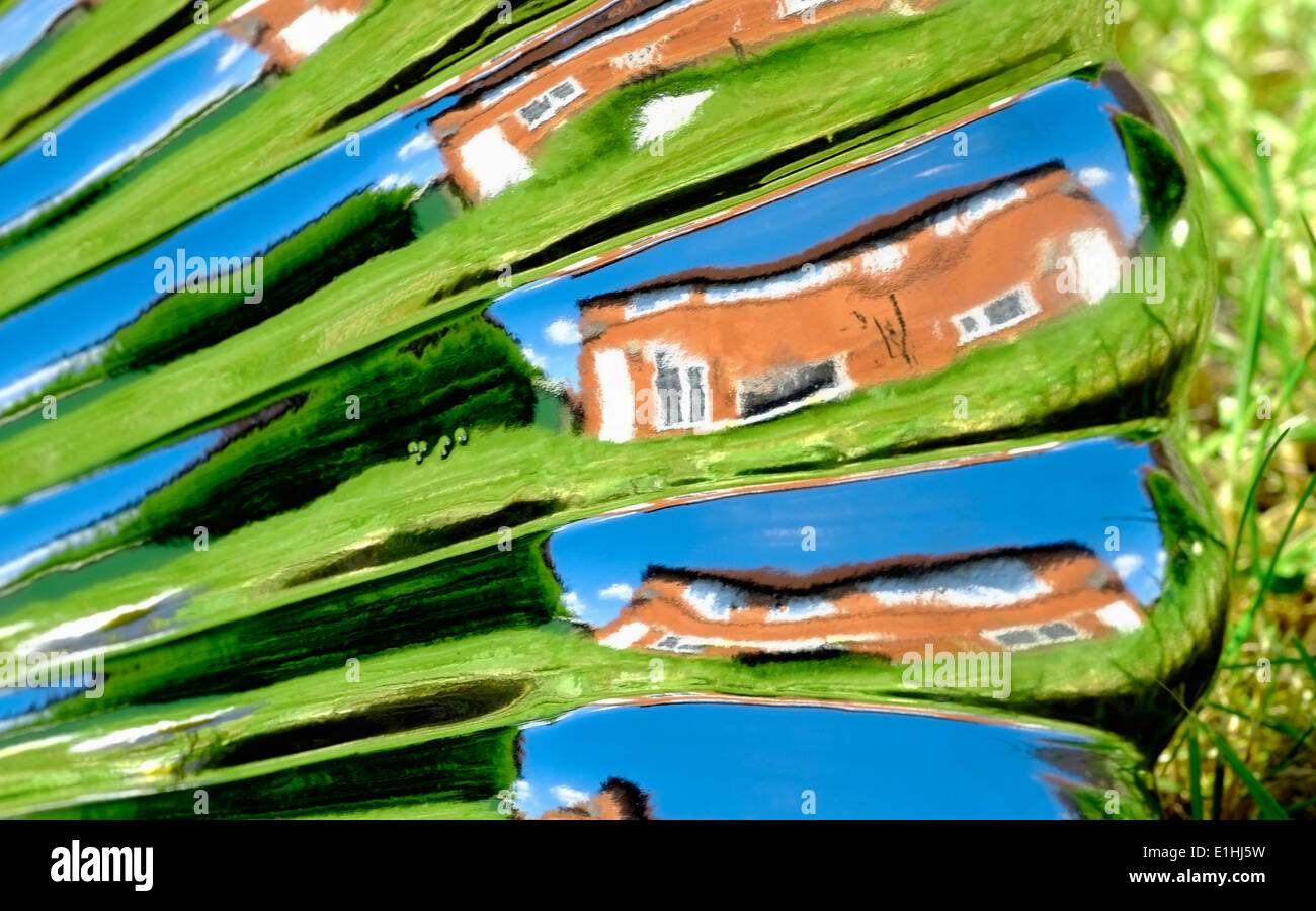 A warped image of a house and garden England uk. Reflection from a garden ornament Stock Photo