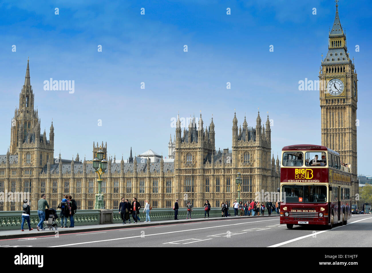 Red double-decker sightseeing bus travelling on Westminster Bridge with Big Ben or Elizabeth Tower, the Palace of Westminster or Stock Photo