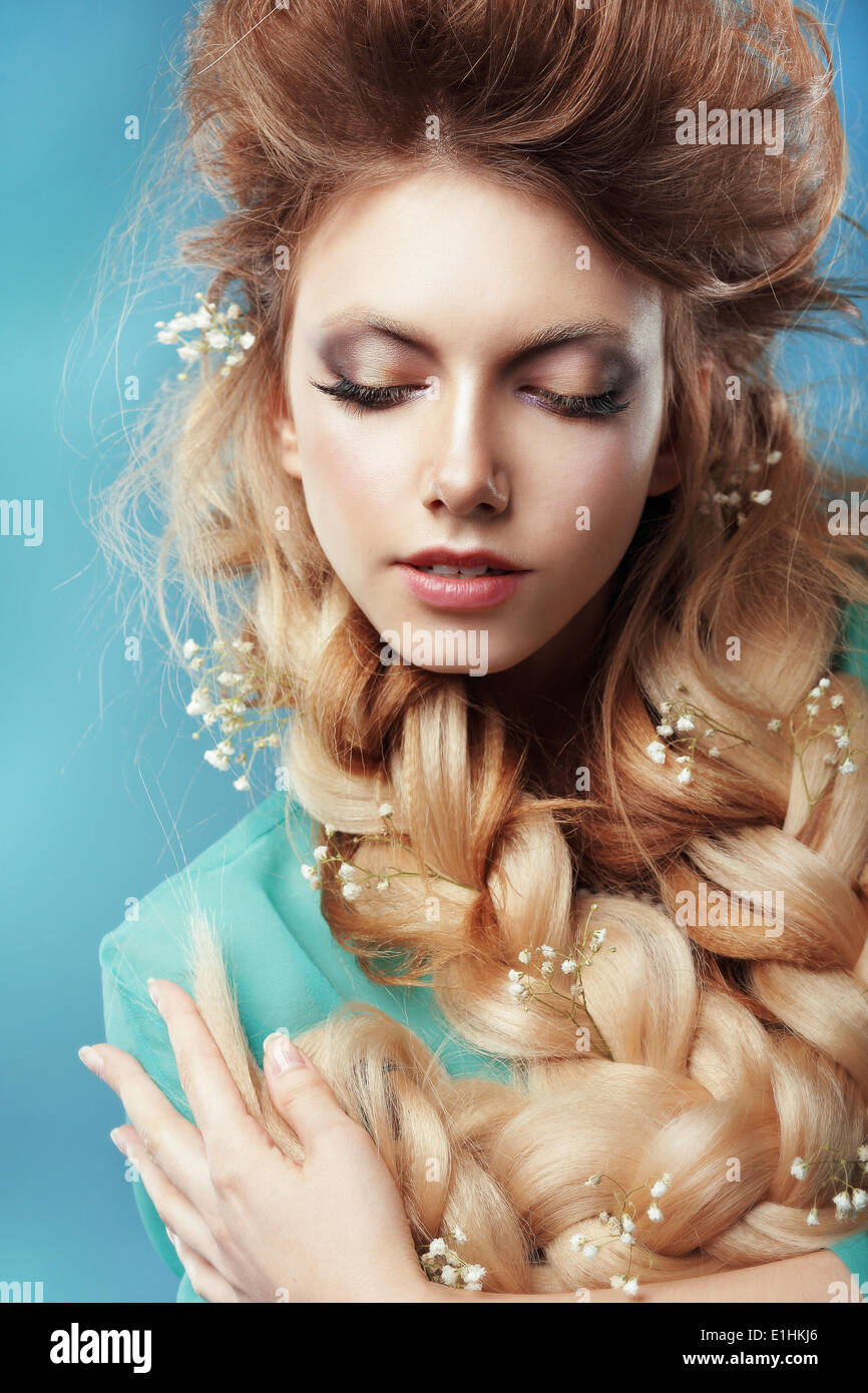 Enjoyment. Woman with Plait and Intertwined Flowers Stock Photo
