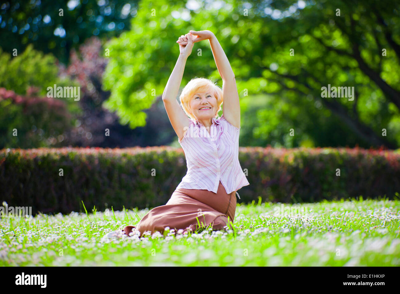 Wellness. Mental Health. Optimistic Old Woman Exercising in Open Air Stock Photo