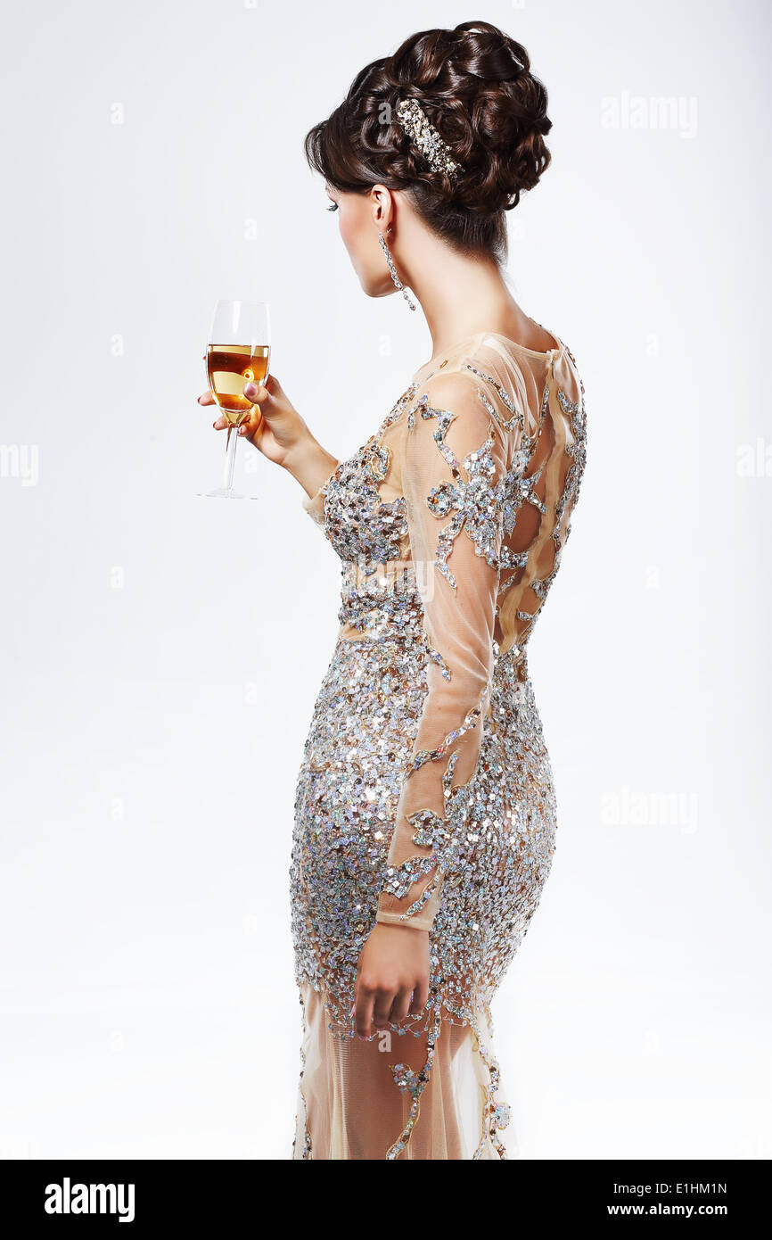Elegant Woman in Silver-Golden Dress holding Wineglass of Champagne. Luxury Stock Photo