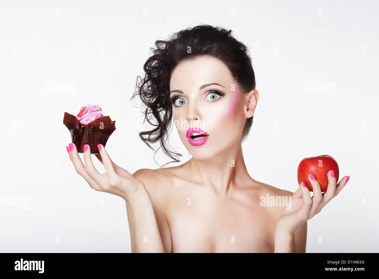 Dieting. Unsure Bewildered Girl Choosing Apple or Cake Stock Photo