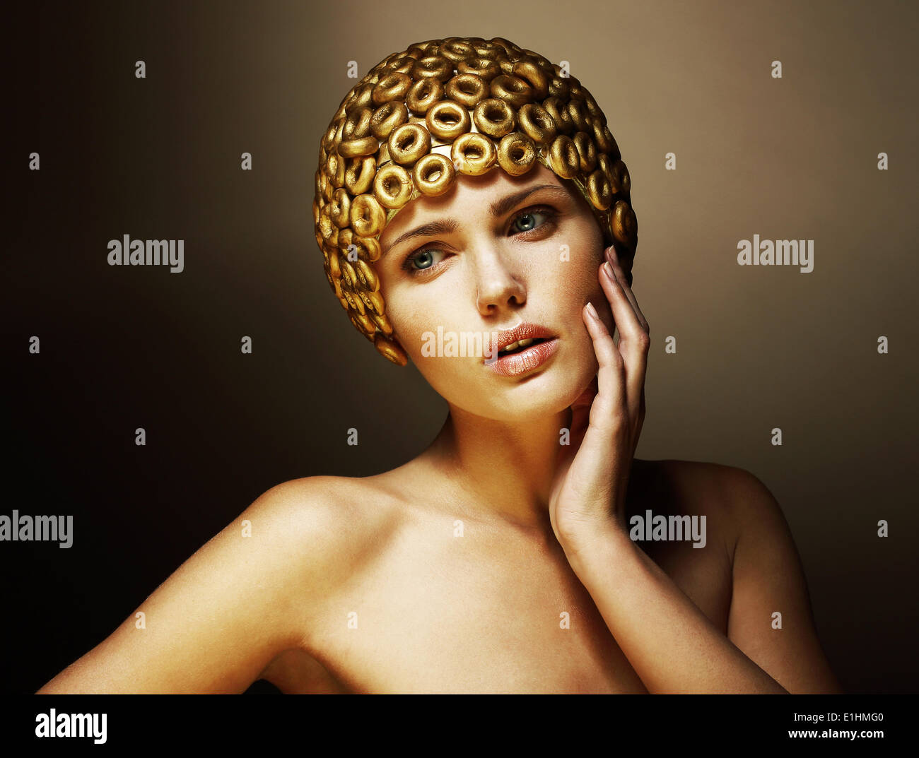 Creativity. Surreal Portrait of Stylized Woman with Golden Headwear as a Helmet Stock Photo