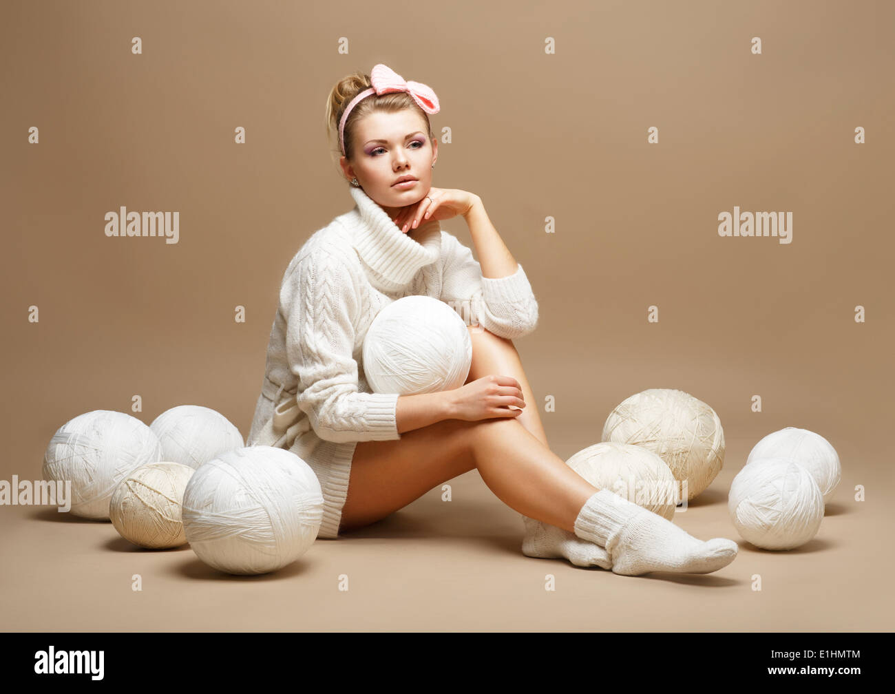 Embroidery. Woman in sitting White Cotton Knitwear with Heap Balls of Yarn Stock Photo