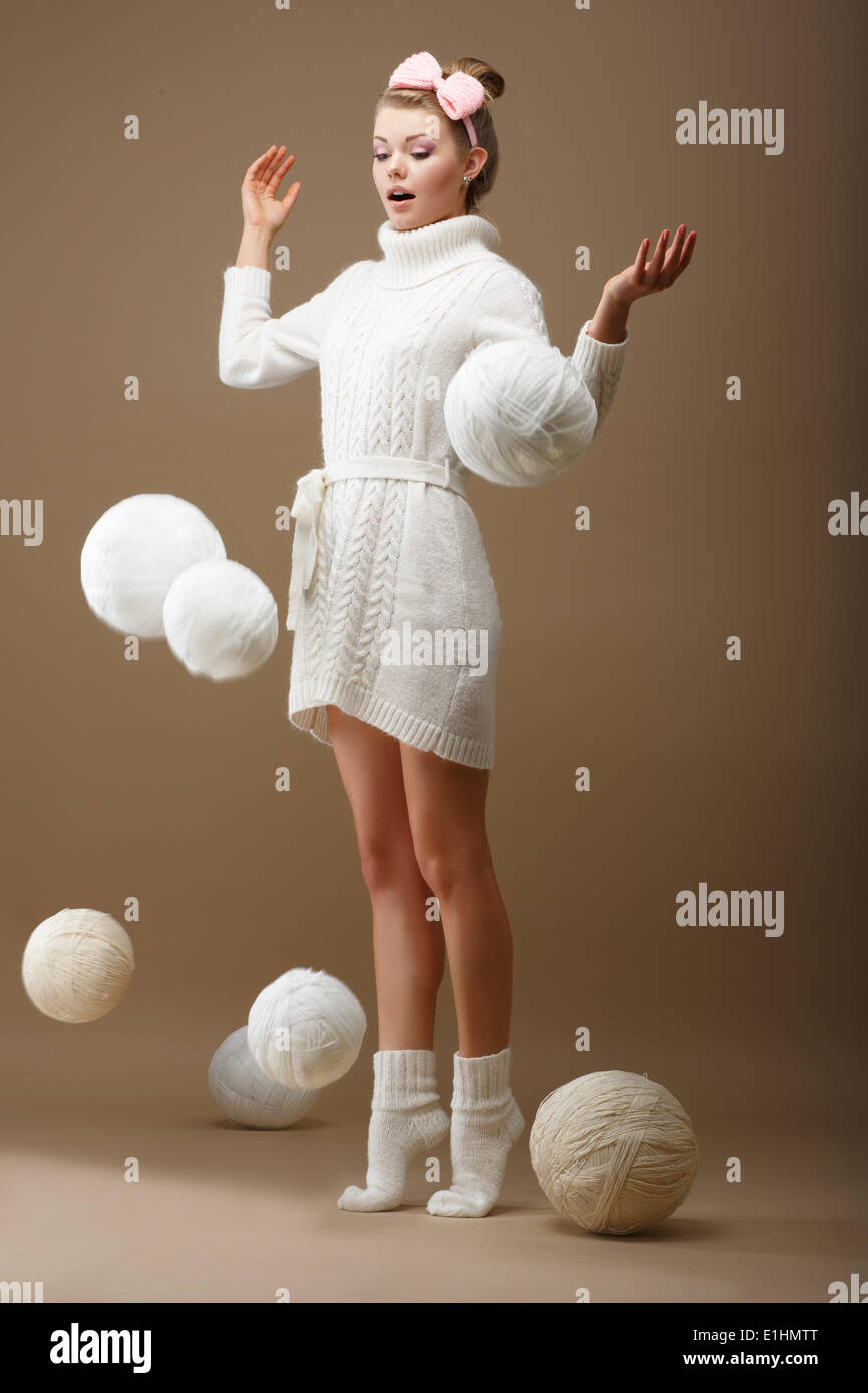 Falling Skeins. Surprised Woman in Woolen Knitted Jersey with White Balls of Yarn Stock Photo
