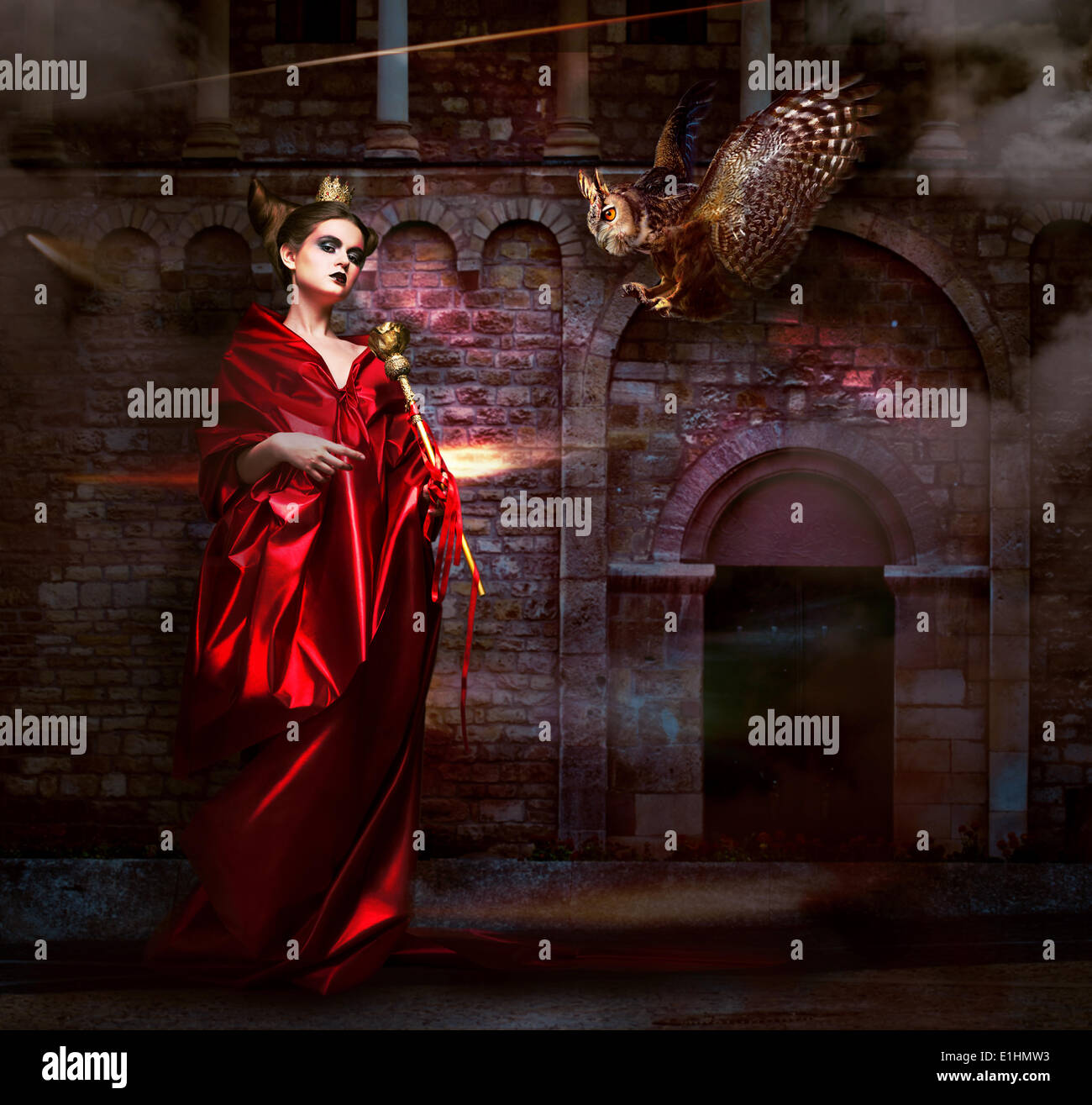 Mysticism.  Witchcraft. Sorcerer in Red Mantle with Vulture - Hawk. Ancient Scary Castle Stock Photo